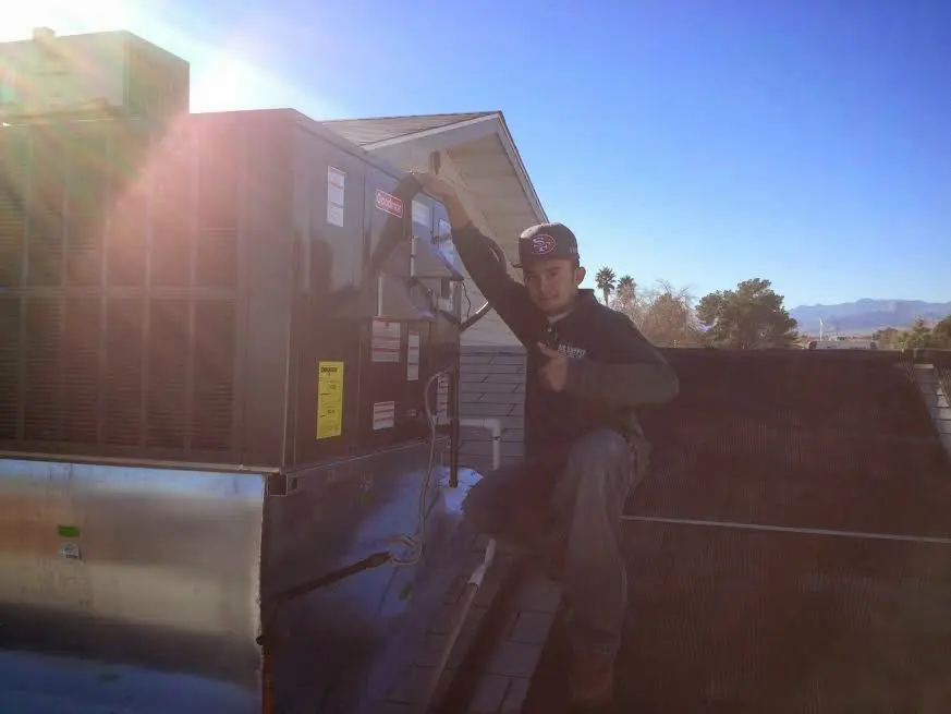 HVAC technician performing Heat Pump Repair on a rooftop unit in Ashland